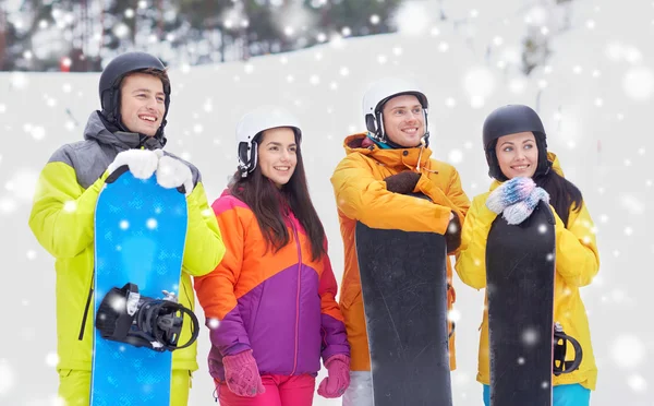 Gelukkige vrienden in helmen met snowboards — Stockfoto