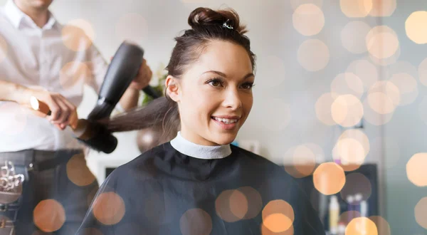 Lycklig kvinna med stylist gör frisyr på salongen — Stockfoto