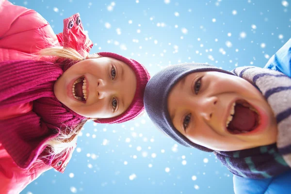 Happy little boy and girl over blue sky with snow — Zdjęcie stockowe