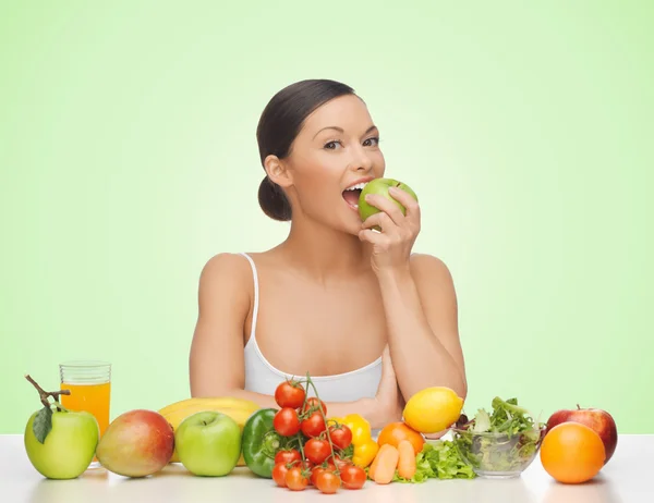 Mulher com frutas e legumes comendo maçã — Fotografia de Stock