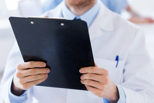 Close up of doctor with clipboard at hospital — Stock Photo, Image