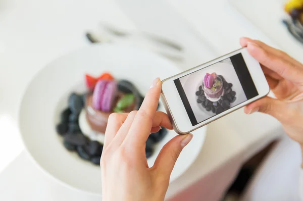 Nahaufnahme einer Frau beim Essen mit dem Smartphone — Stockfoto