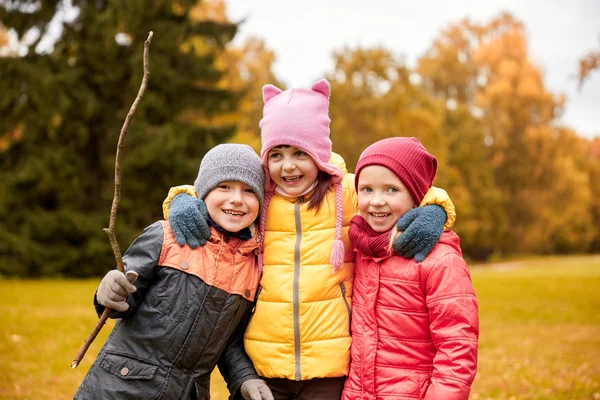 Gruppo di bambini felici che si abbracciano nel parco autunnale — Foto Stock