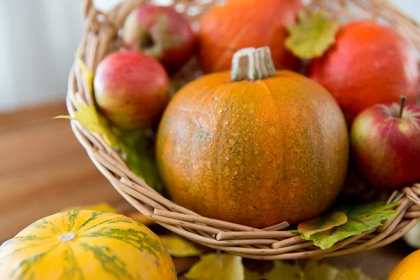 Close up of pumpkins in basket on wooden table — Stock Photo, Image