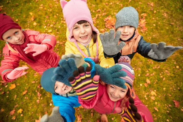 Niños felices saludando las manos en el parque de otoño —  Fotos de Stock