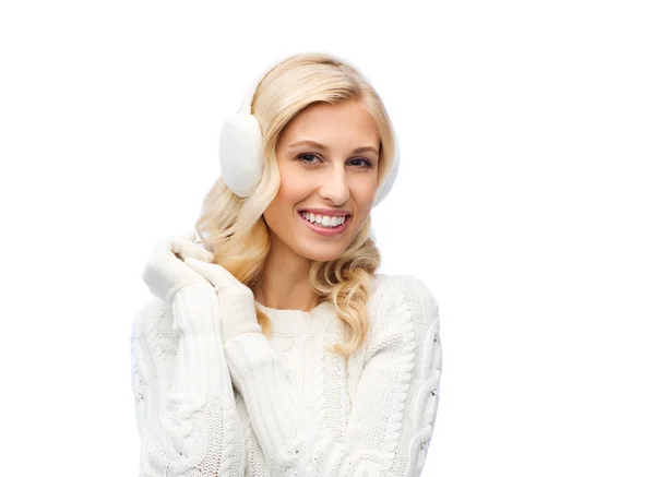 Leende ung kvinna i vinter öronmuffar och tröja Stockbild