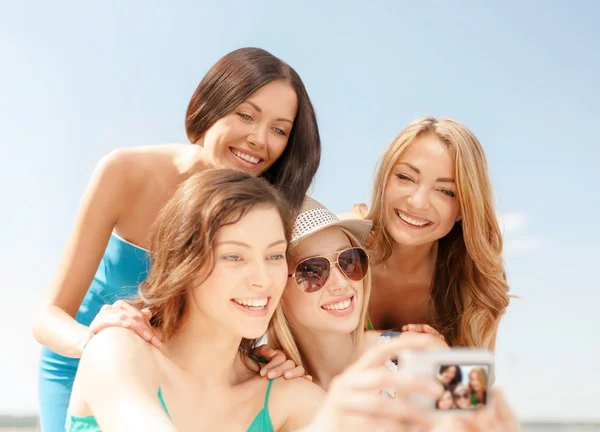 Chicas sonrientes tomando fotos en el café en la playa —  Fotos de Stock