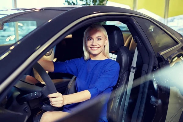 Glückliche Frau im Auto in Autoshow oder Salon — Stockfoto