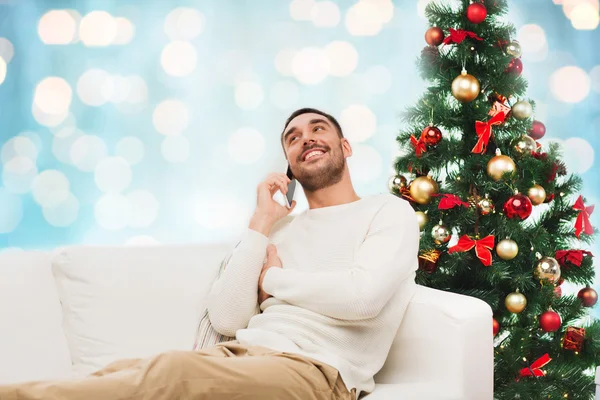 Man calling on smartphone over christmas lights — 스톡 사진