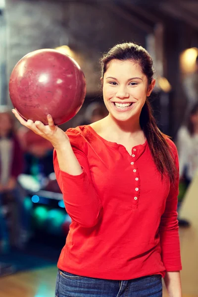 Happy young woman holding ball in bowling club — Stock Photo, Image