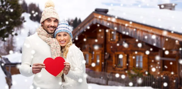 Happy couple in winter clothes with heart outdoors — Stock Photo, Image