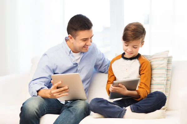 Счастливые отец и сын с планшетным компьютером дома — стоковое фото