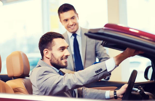 Homem feliz com negociante de carro em auto show ou salão de beleza — Fotografia de Stock