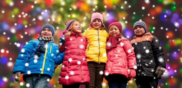 Happy children over snow and christmas lights — 图库照片