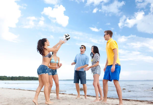 Grupo de amigos felizes jogando bola de praia — Fotografia de Stock