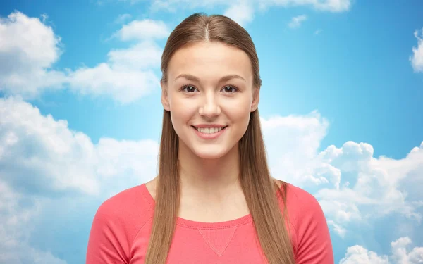 Smiling young woman or teenage girl over blue sky — Stock Photo, Image