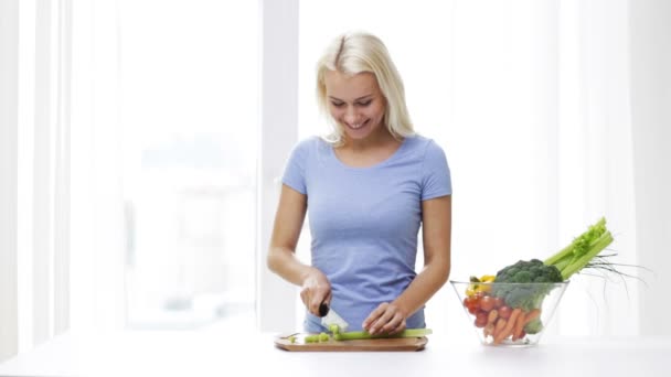 微笑的年轻女子在家里切芹菜 — 图库视频影像
