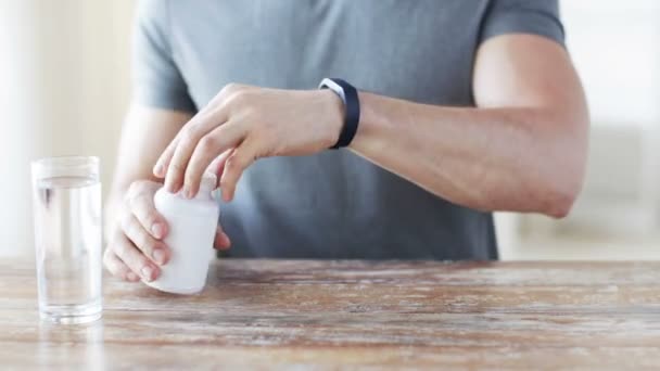 Nahaufnahme eines Mannes, der Pillen aus dem Glas in die Hand schüttet — Stockvideo