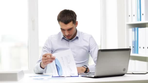 Busy businessman with laptop and papers in office — Stock Video