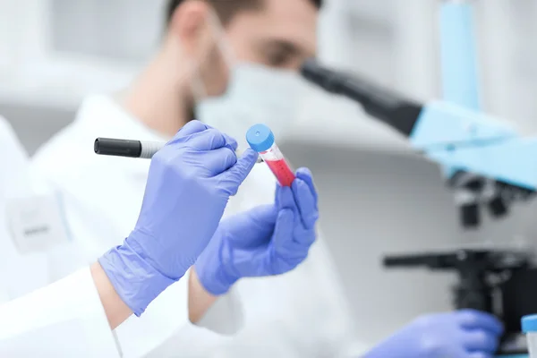 Primo piano delle mani degli scienziati con provetta in laboratorio — Foto Stock