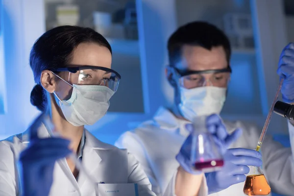 Perto de cientistas que fazem testes em laboratório — Fotografia de Stock