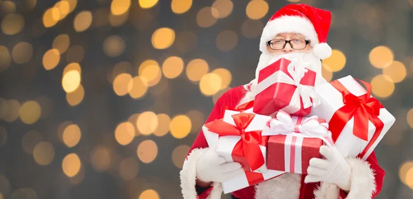 Человек в костюме Санта-Клауса с подарочными коробками — стоковое фото