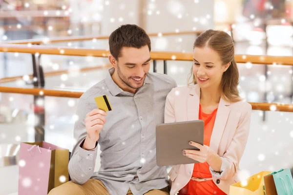 Pareja con tablet pc y tarjeta de crédito en el centro comercial —  Fotos de Stock