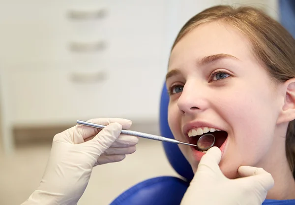 Mains avec miroir dentaire vérifier les dents de fille — Photo