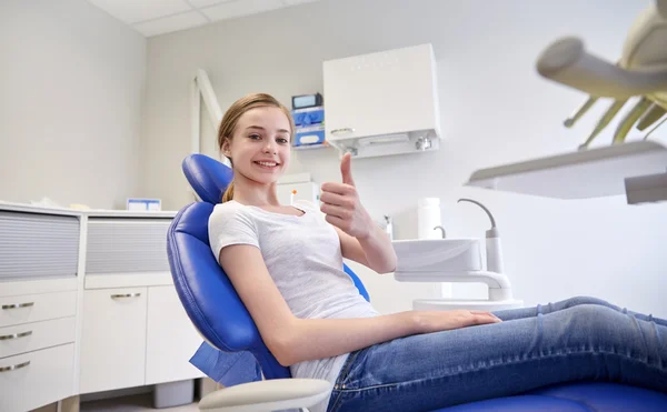 Menina paciente feliz mostrando polegares para cima na clínica — Fotografia de Stock