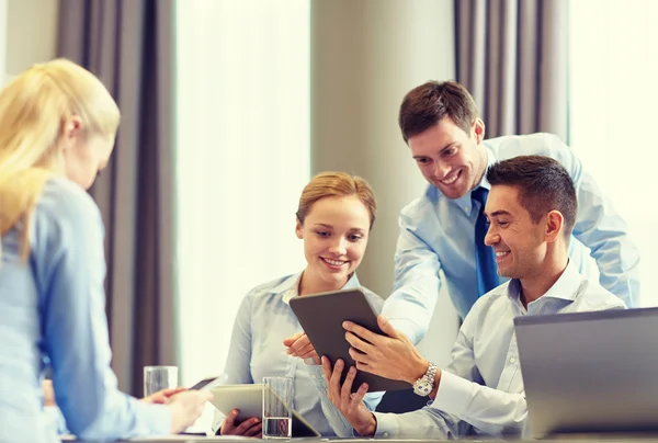 Glimlachende mensen uit het bedrijfsleven met de tablet pc in office — Stockfoto