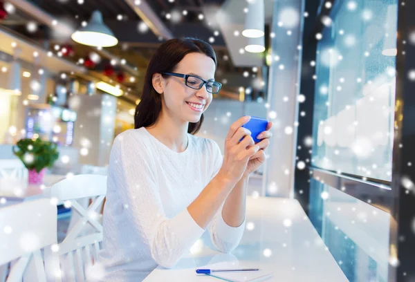 Mujer sonriente con teléfono inteligente en la cafetería — Foto de Stock