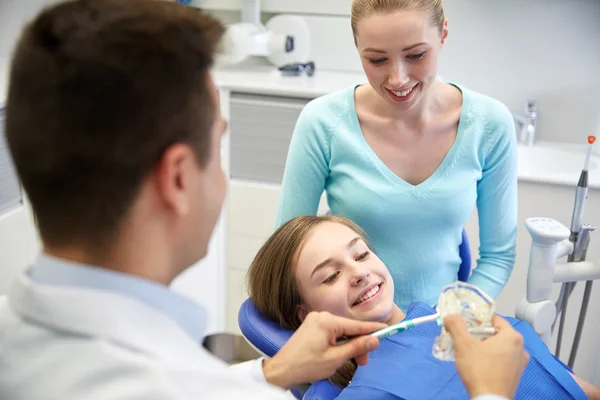 행복 한 치과 의사 표시 칫 솔 환자 소녀에 게 — 스톡 사진