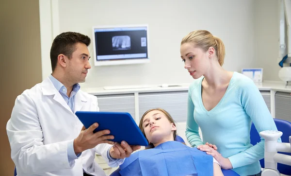 牙医展示平板电脑给女孩和她的母亲 — 图库照片
