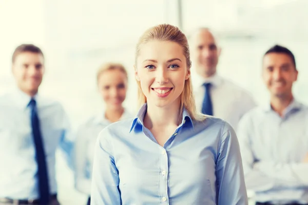 Mujer de negocios sonriente con colegas en el cargo — Foto de Stock