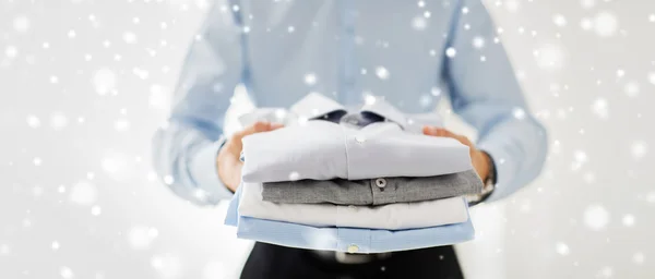 Close up of businessman holding folded shirts — Stock Photo, Image