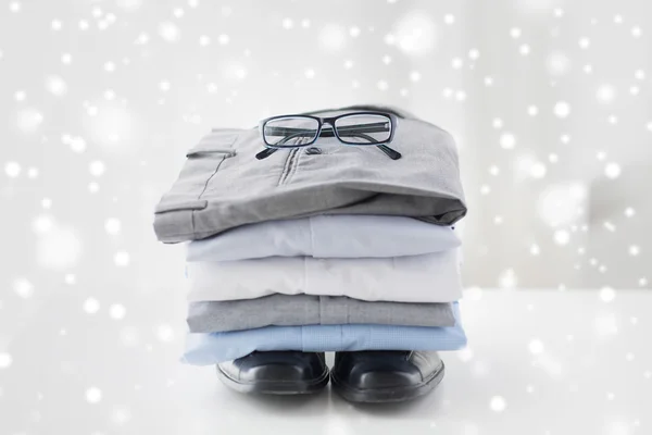 Close up of folded male shirts and shoes on table — Stock Photo, Image