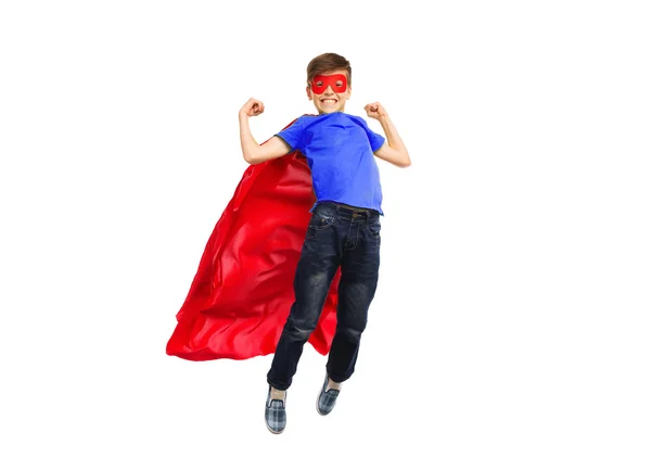 Boy in red super hero cape and mask flying on air — Stock fotografie