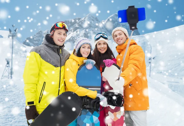 Happy přátelé se snowboardy a smartphone — Stock fotografie