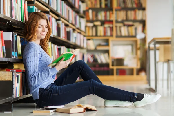 Student szczęśliwy dziewczyna czytania książki w bibliotece — Zdjęcie stockowe