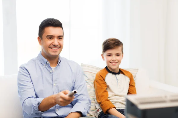 Souriant père et fils regarder la télévision à la maison — Photo