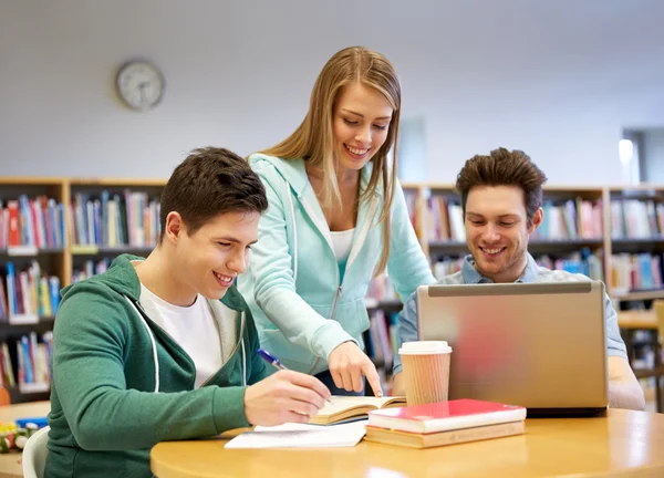 Ευτυχισμένος φοιτητές με laptop και βιβλία στην βιβλιοθήκη — Φωτογραφία Αρχείου