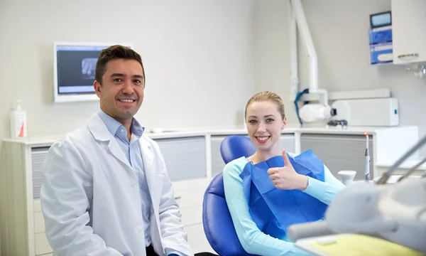 Dentista masculino feliz con paciente mujer en la clínica —  Fotos de Stock