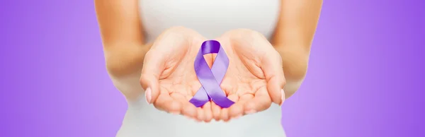 Close up of hands holding purple awareness ribbon — Zdjęcie stockowe