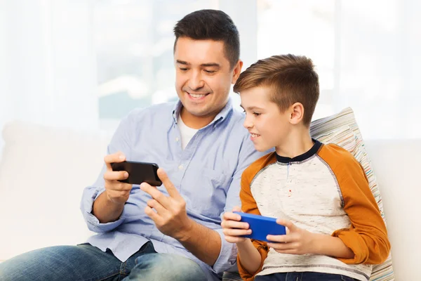 Feliz padre e hijo con smartphones en casa — Foto de Stock