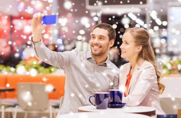 Happy couple with smartphone taking selfie in mall — Stock Photo, Image