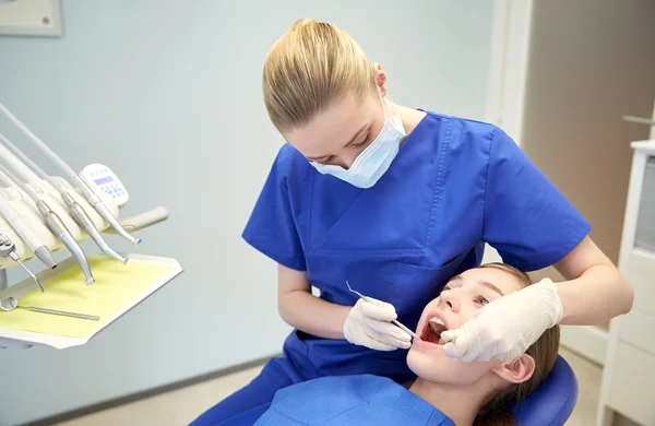 Kvinnliga tandläkare kontrollera patientens tjej tänder — Stockfoto