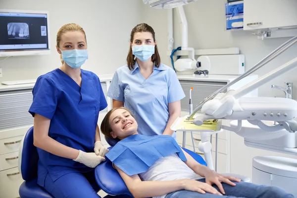 Dentista mujer feliz con chica paciente en la clínica —  Fotos de Stock