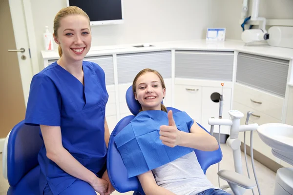 Dentista mujer feliz con chica paciente en la clínica — Foto de Stock