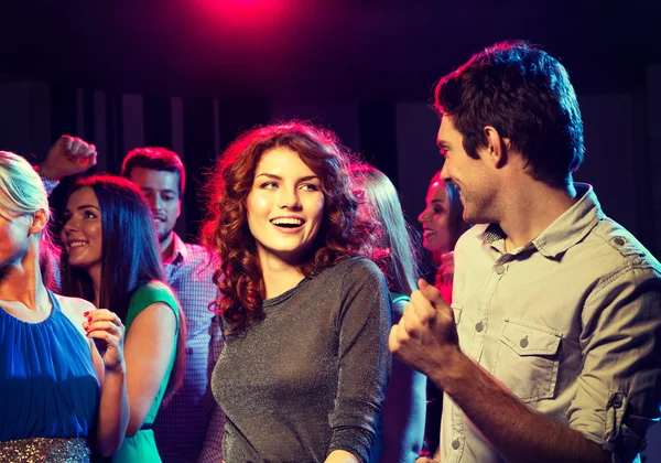 Smilende venner danser i klubben - Stock-foto