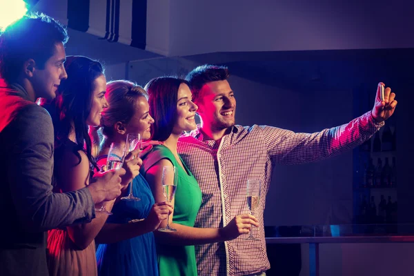 Friends with glasses and smartphone in club — Stock Photo, Image